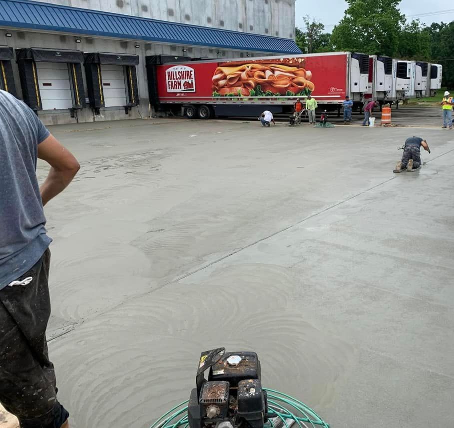 A man is standing in a parking lot in front of a truck with a hamburger on it.
