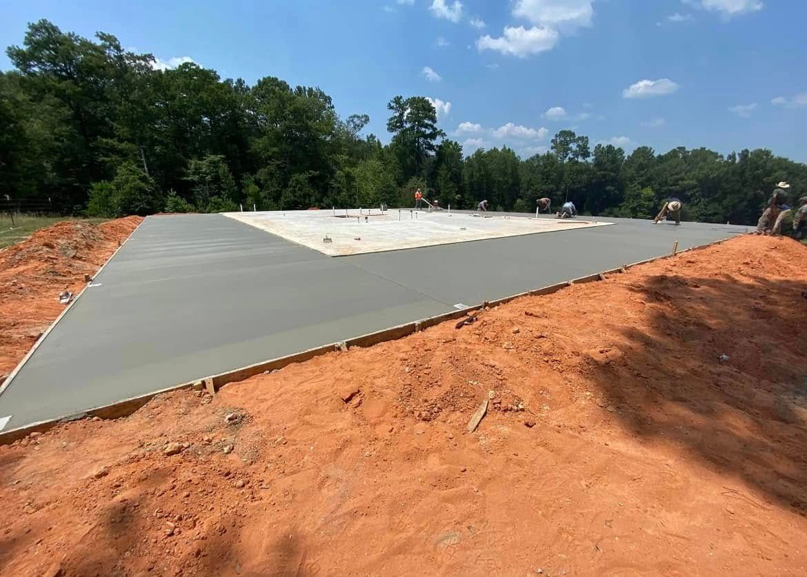 A concrete driveway is being built in a dirt field.