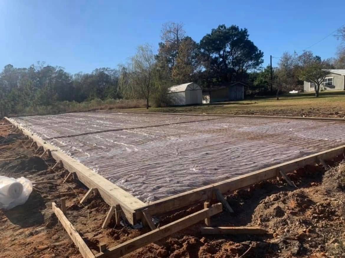 A large concrete slab is sitting in the middle of a dirt field.