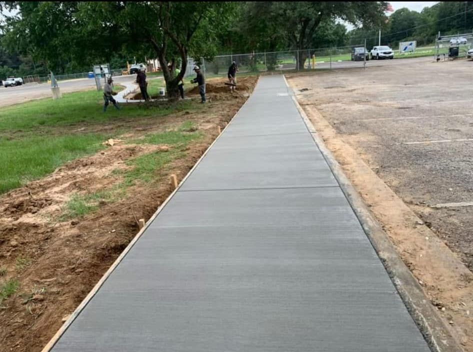 A concrete walkway is being built in a parking lot.