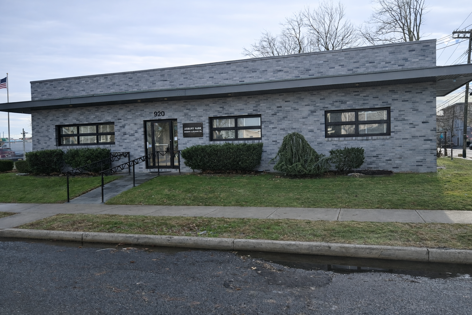 Two multi-story beach houses on sandy dunes under a clear blue sky.