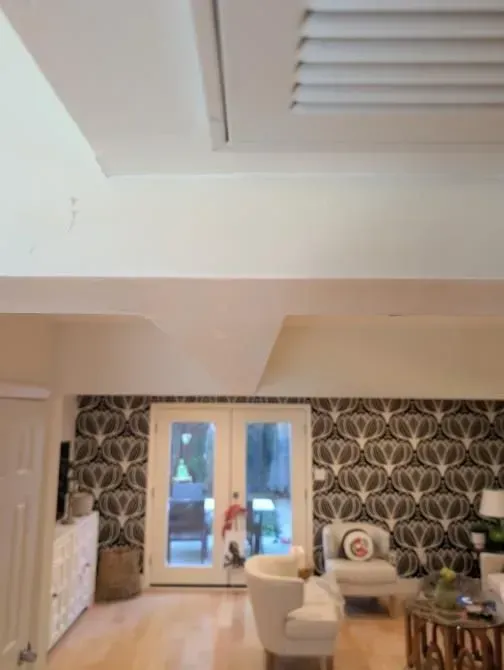 A living room with chairs and a sliding glass door