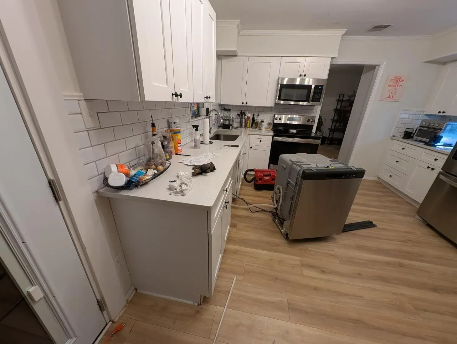 A kitchen with white cabinets and stainless steel appliances.