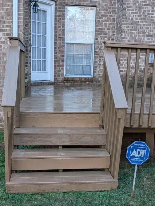 A wooden deck with stairs and a sign that says adt