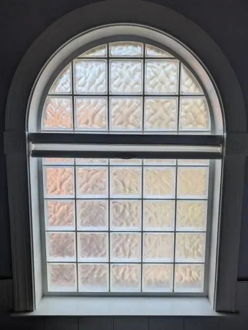 A window with a white frame and a stained glass window