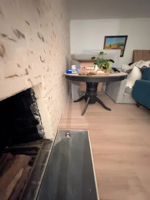 A living room with a fireplace and a table