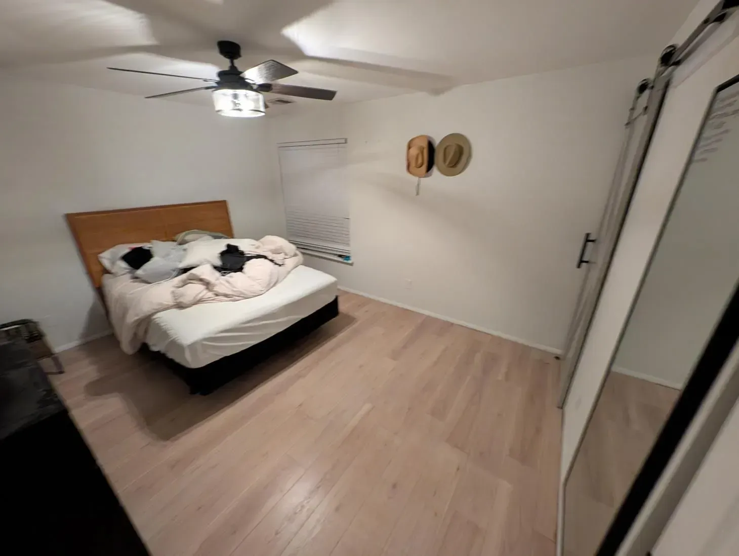 A bedroom with a bed and a ceiling fan
