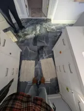 A person standing in a bathroom with a marble floor