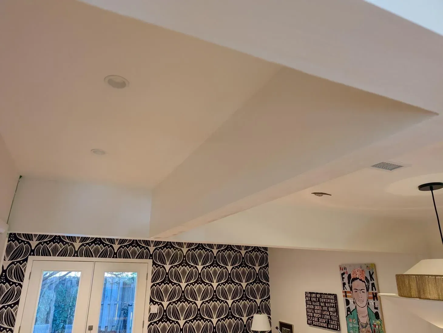 A room with a white ceiling and black and white wallpaper