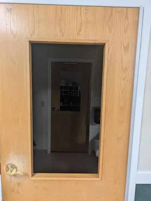 A wooden door with a small window in it.