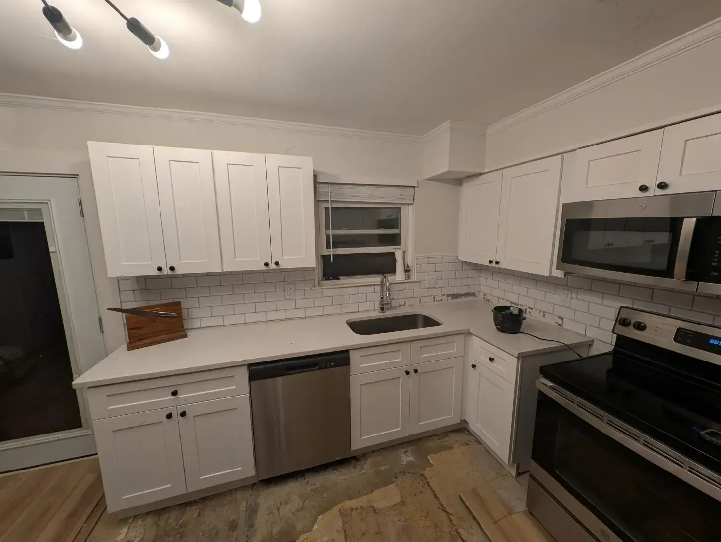 A kitchen with white cabinets and stainless steel appliances.