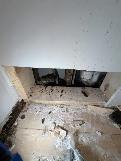 A hole in a wall with a pipe coming out of it.