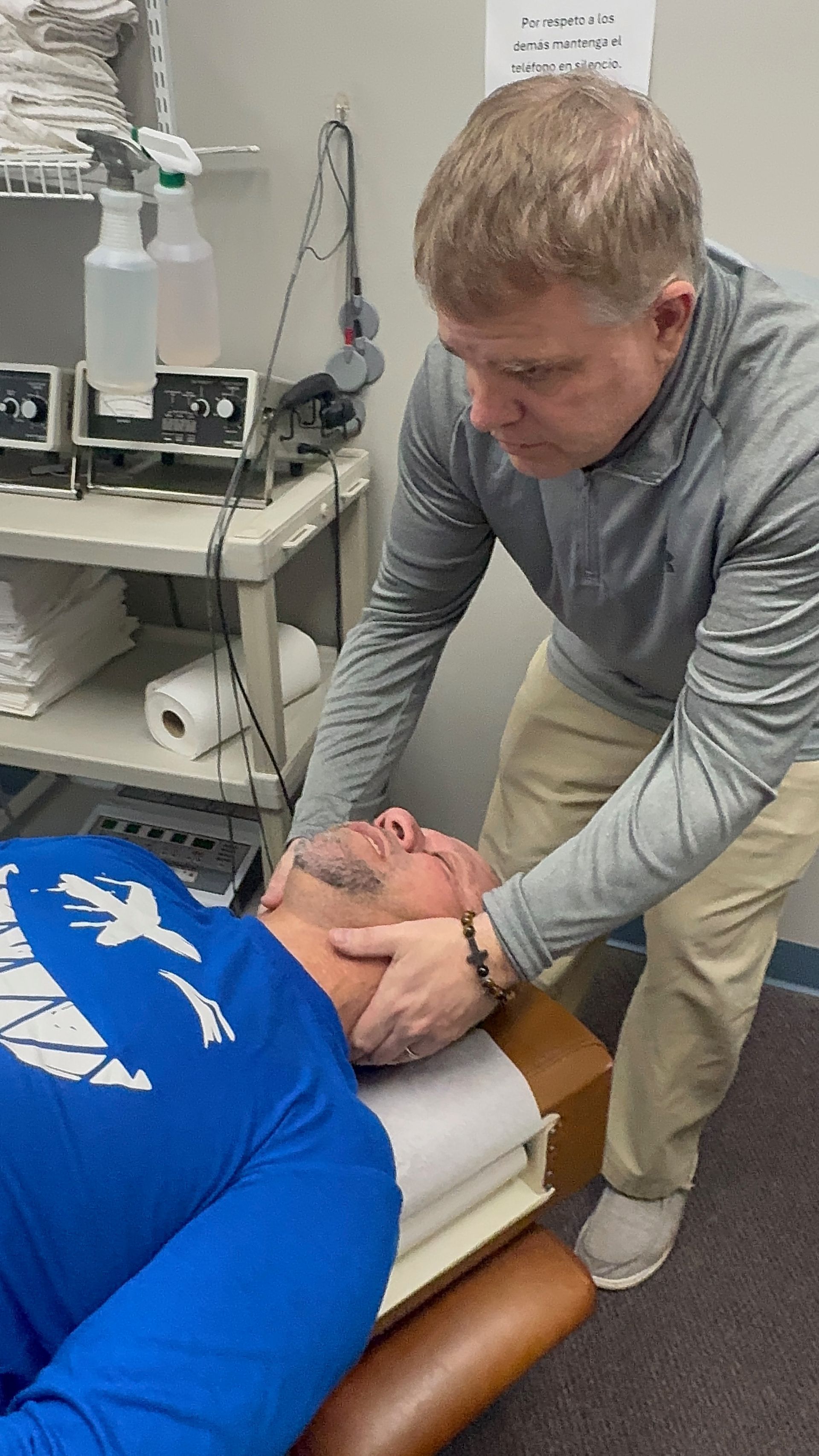 Person receiving back massage, hands applying pressure on the shoulder and back.