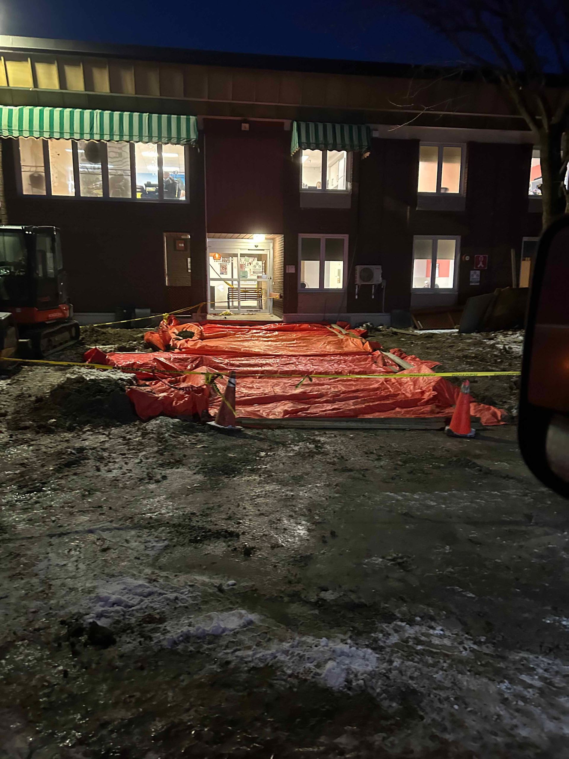 Un grand bâtiment avec beaucoup de bâches rouges sur le sol devant lui.