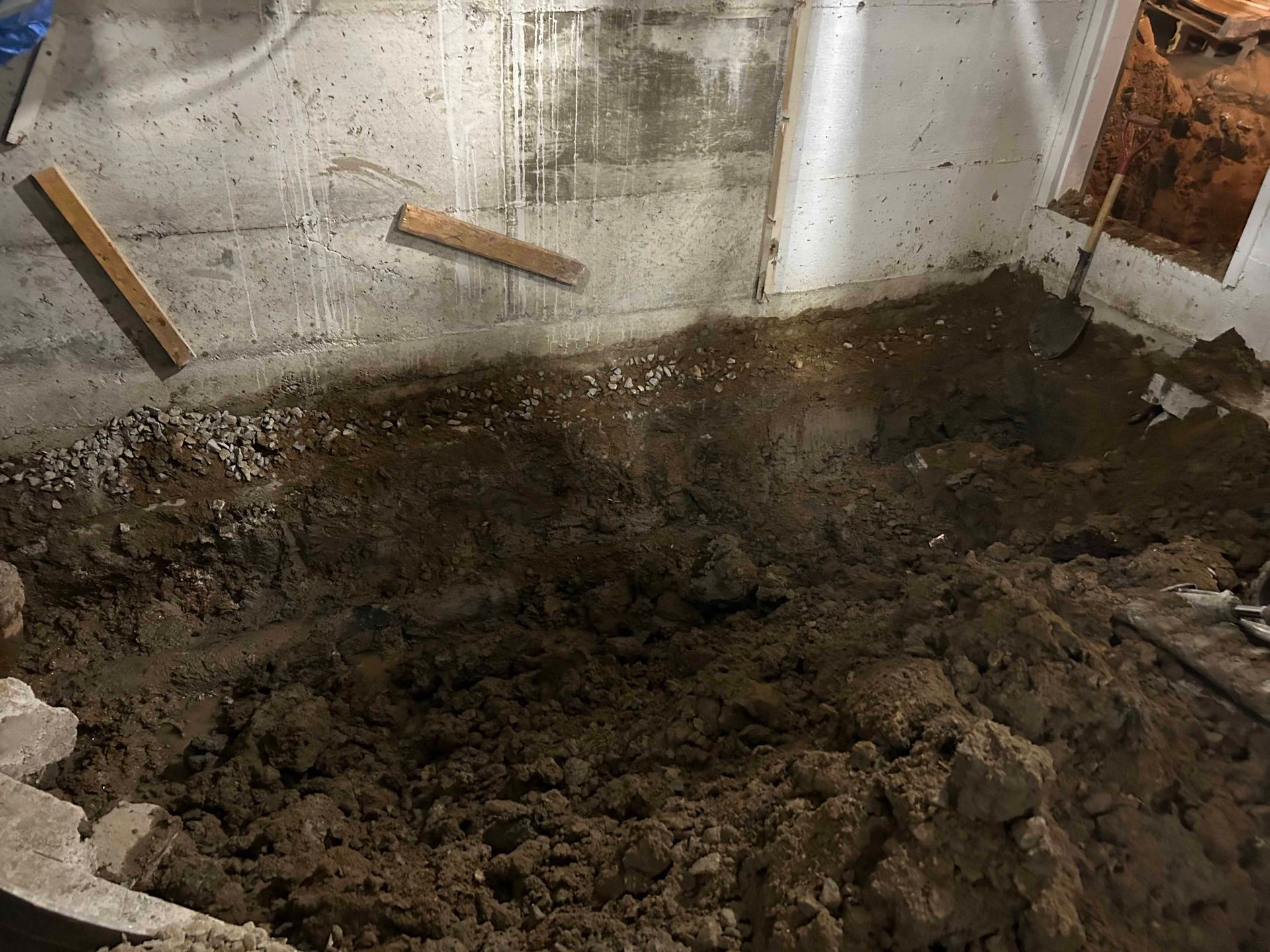 Un tas de terre dans un sous-sol avec une pelle.