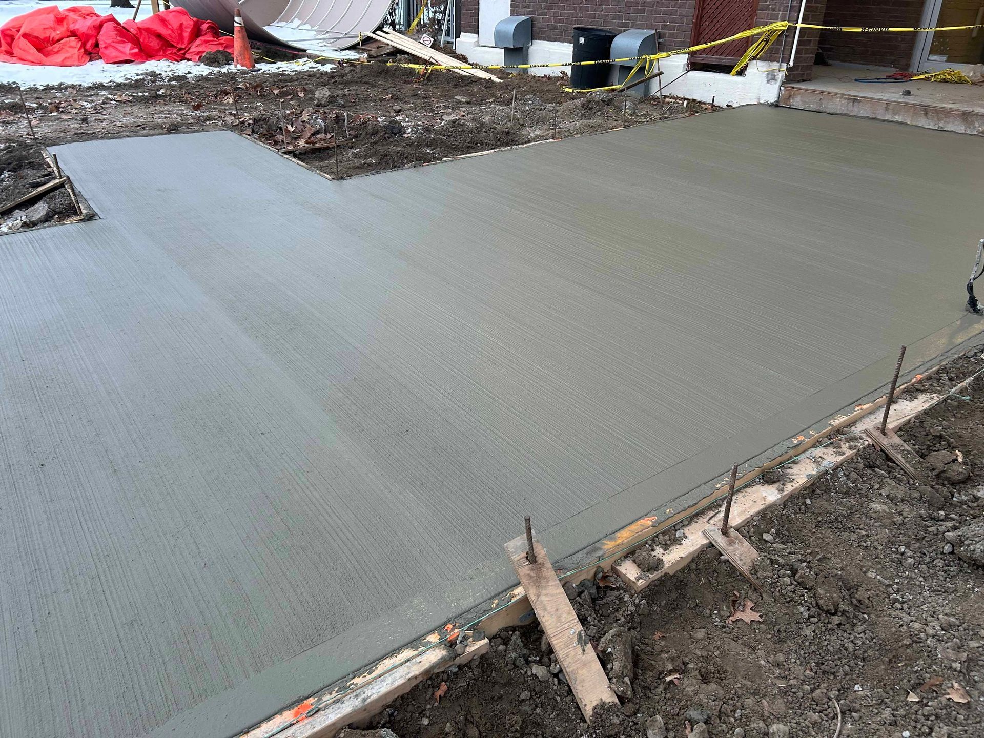 Une passerelle en béton est en cours de construction devant une maison.