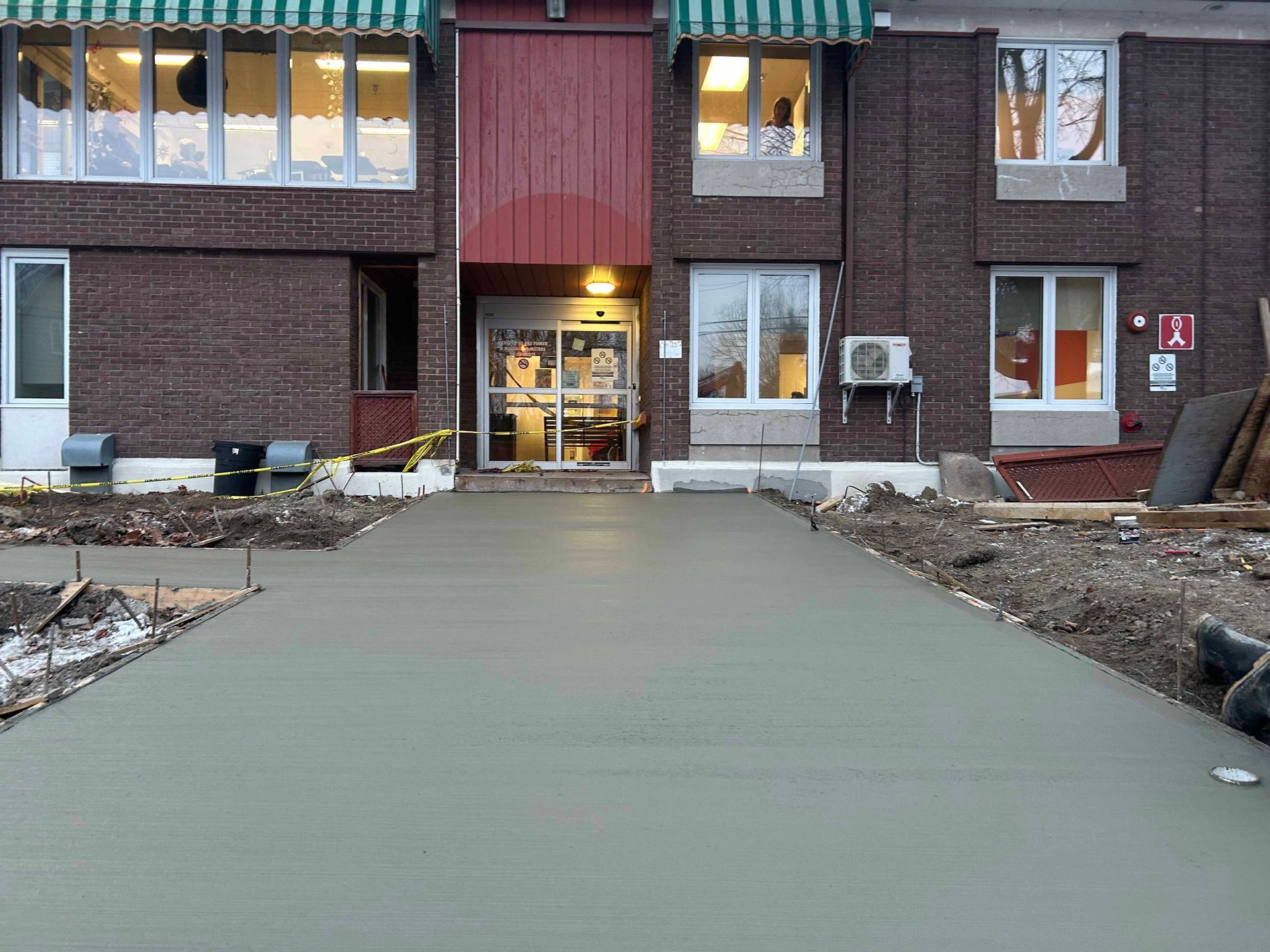 Un bâtiment en briques avec une passerelle en béton qui y mène