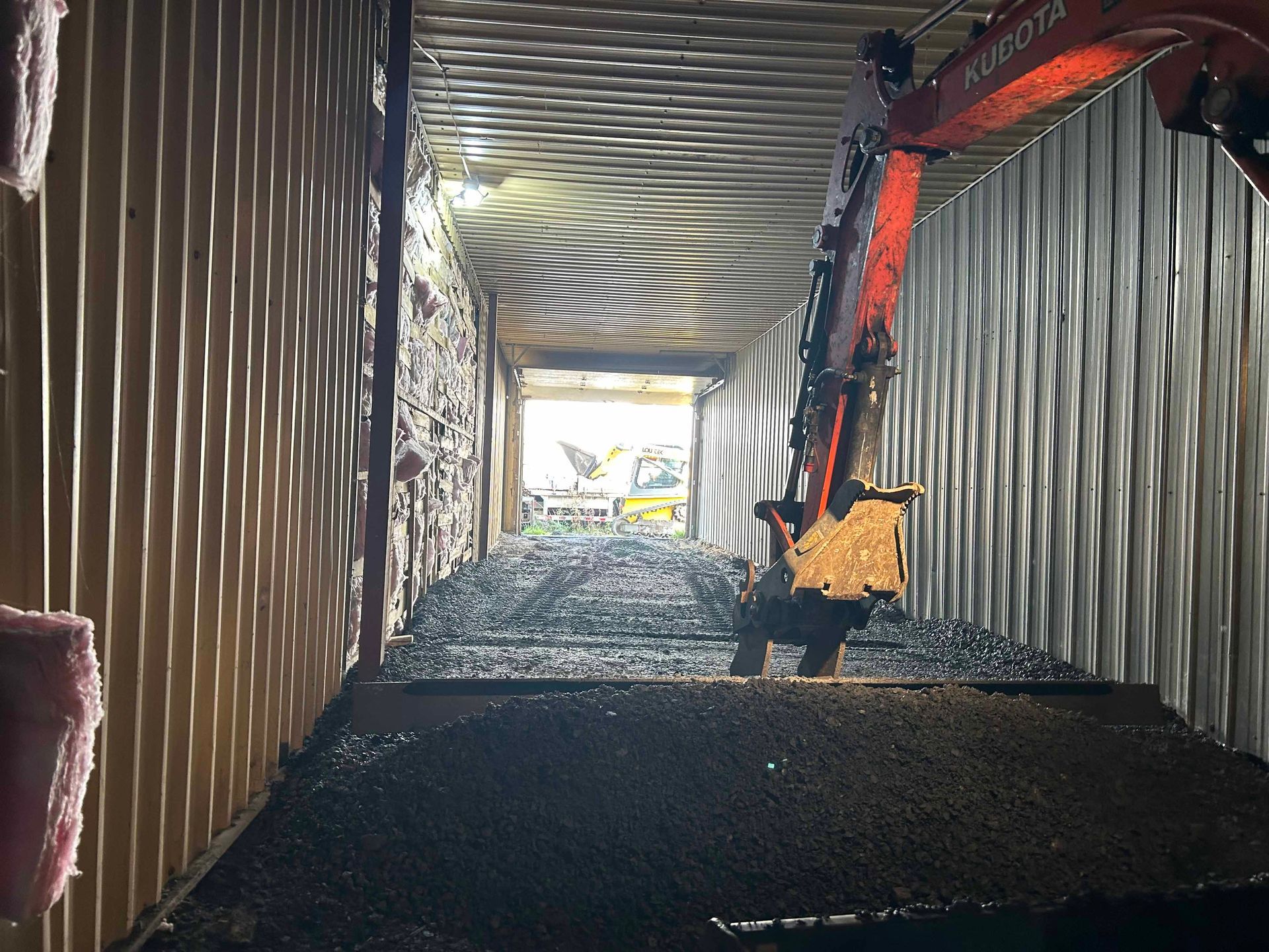 Une excavatrice Kubota est à l'intérieur d'un conteneur d'expédition