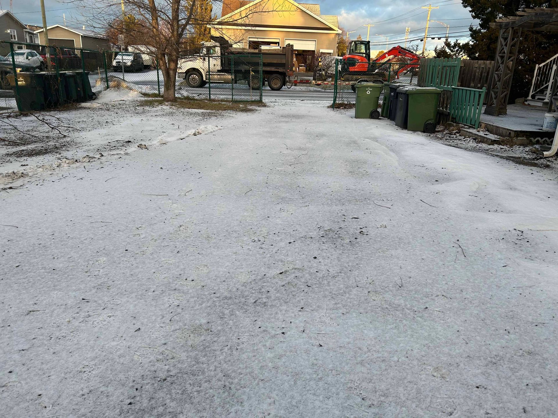 Un parking recouvert de neige avec un camion garé en arrière-plan.