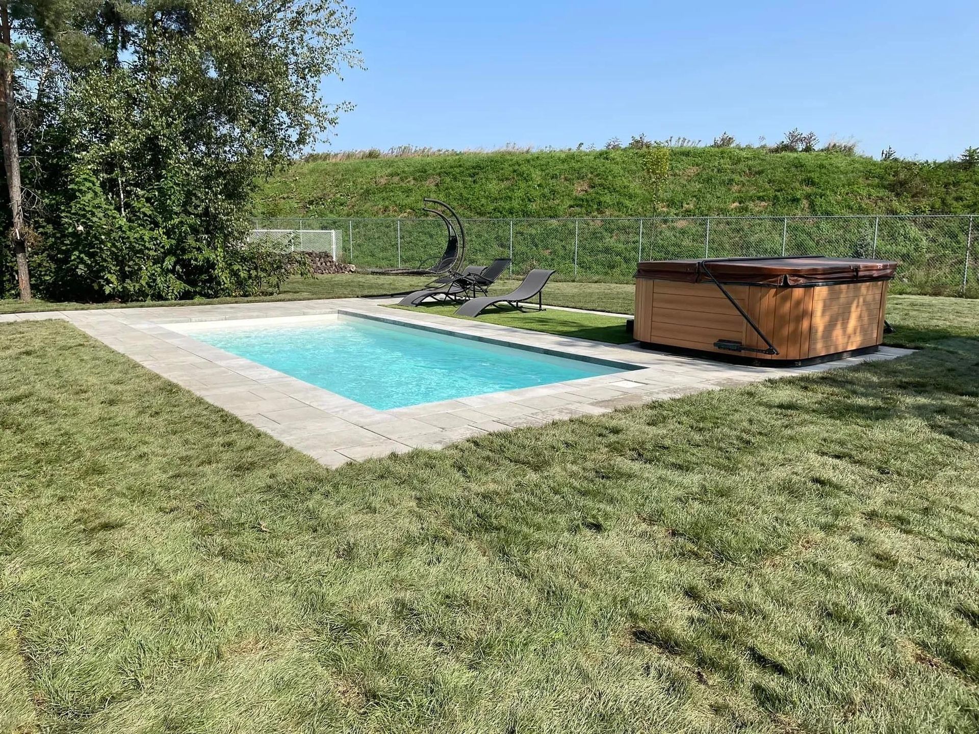 Une grande piscine avec un jacuzzi au milieu.