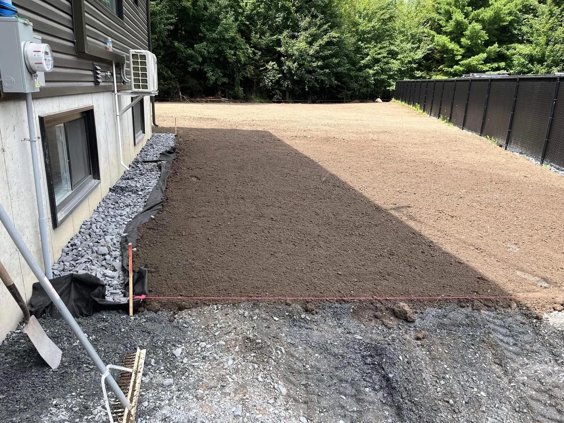 Une allée de gravier est en cours de construction devant une maison.