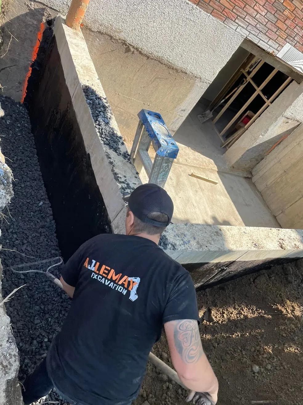 Un homme en chemise noire creuse un trou dans le sol.