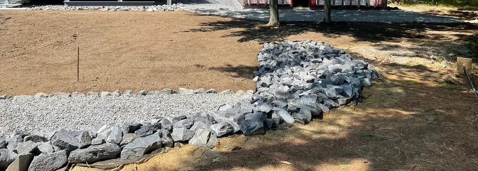 Un tas de pierres est posé sur le sol devant une maison.