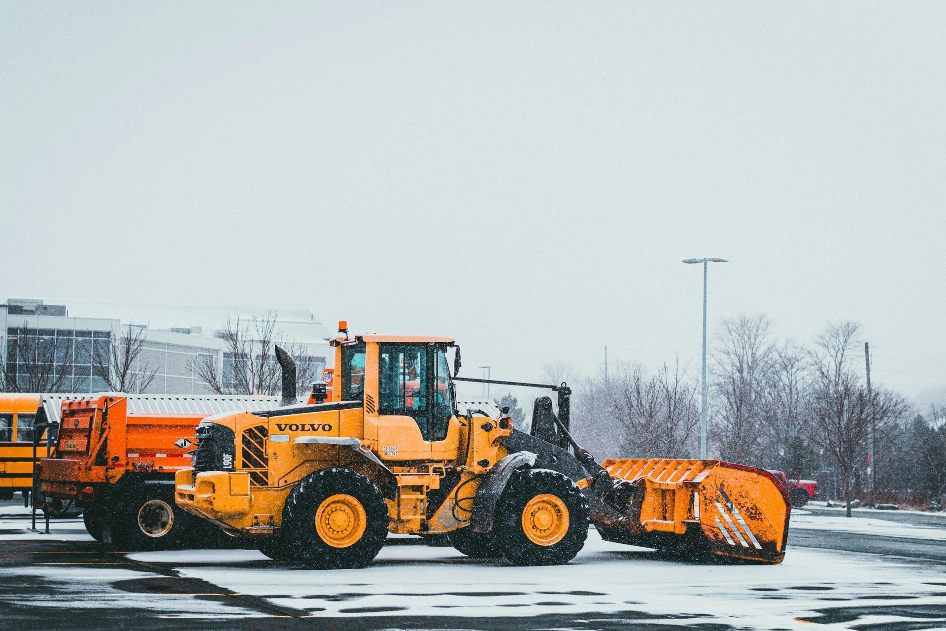 Seasonal snow removal team preparing equipment for commercial lot