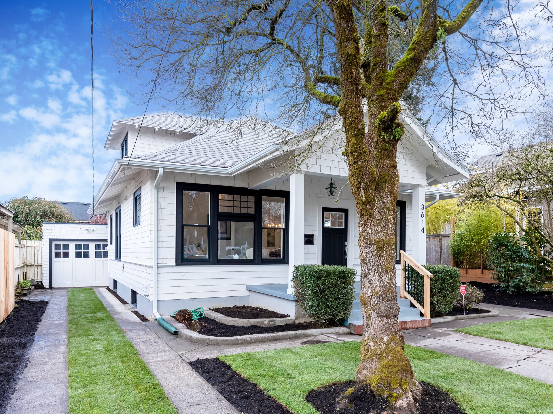 Picture of front of the house with a tree in front.