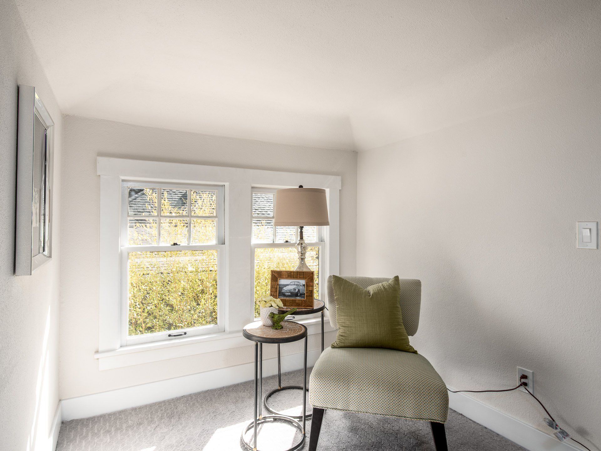 Picture of a chair and lamp in front of a window.