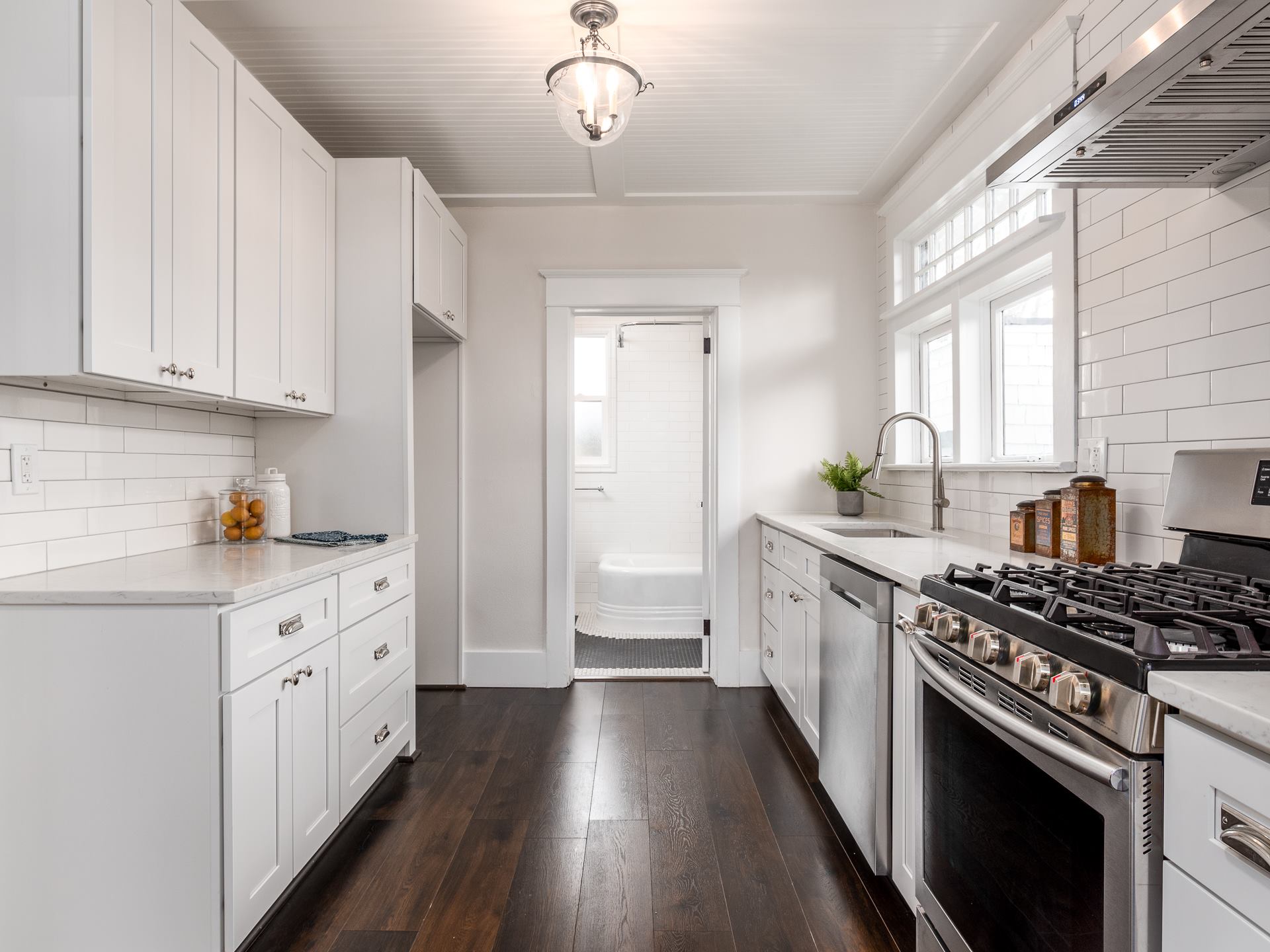 Picture of a galley kitchen that's mostly white.