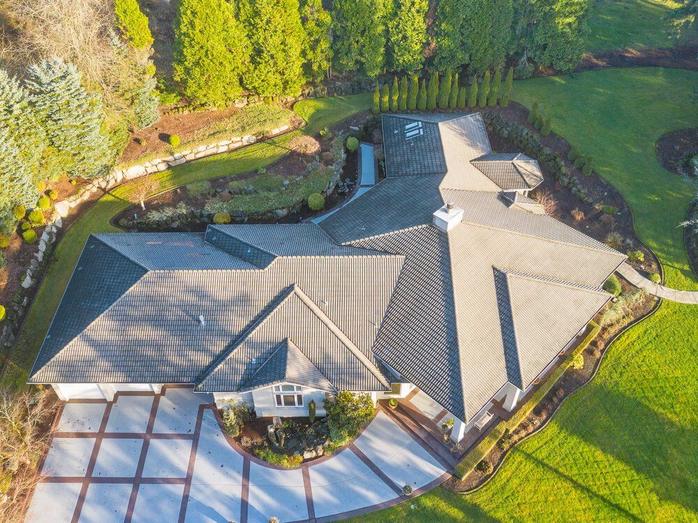Drone photo of a single story house and grass surrounding.