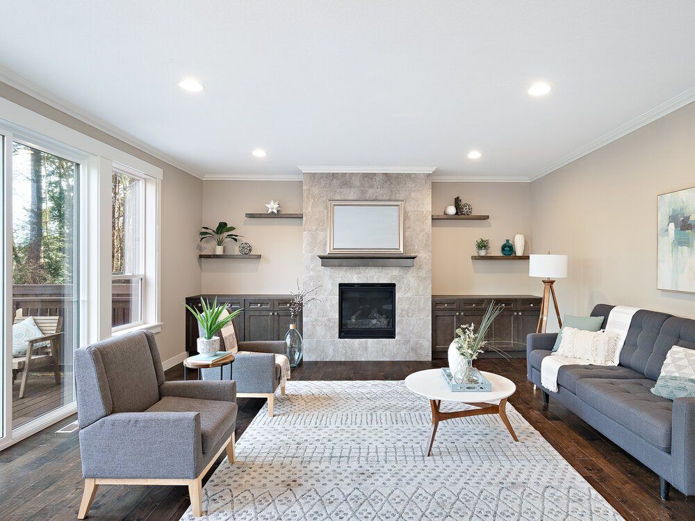 Photo of a living room with a fireplace in the middle on the wall.