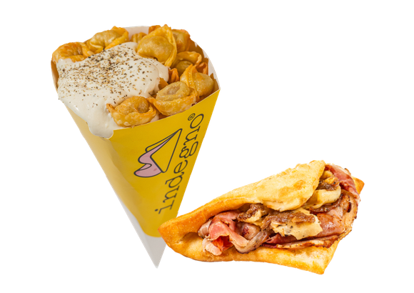 Un cono giallo ripieno di pasta condita con salsa bianca, accanto a una focaccia piegata e farcita con carne a fette.