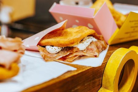 Un panino salato fritto con prosciutto e formaggio morbido
