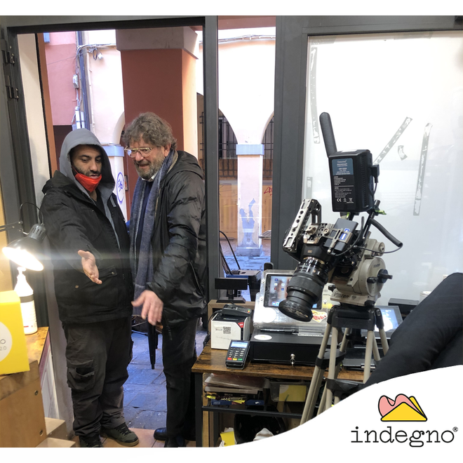 Due persone in piedi all'ingresso di un negozio che parlano