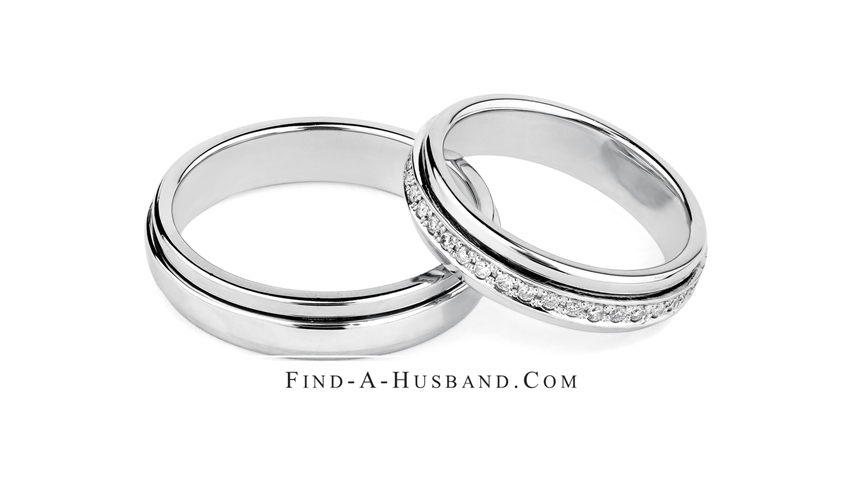 A pair of wedding rings are sitting next to each other on a white background.