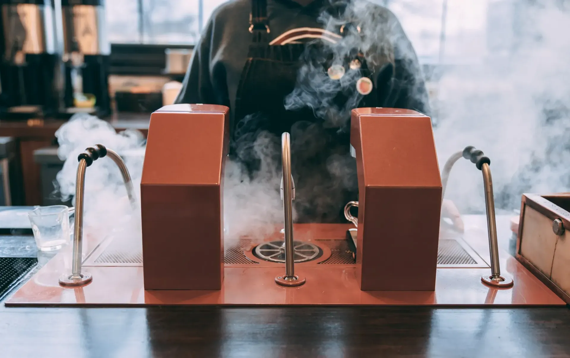 A person is standing in front of a machine with smoke coming out of it.