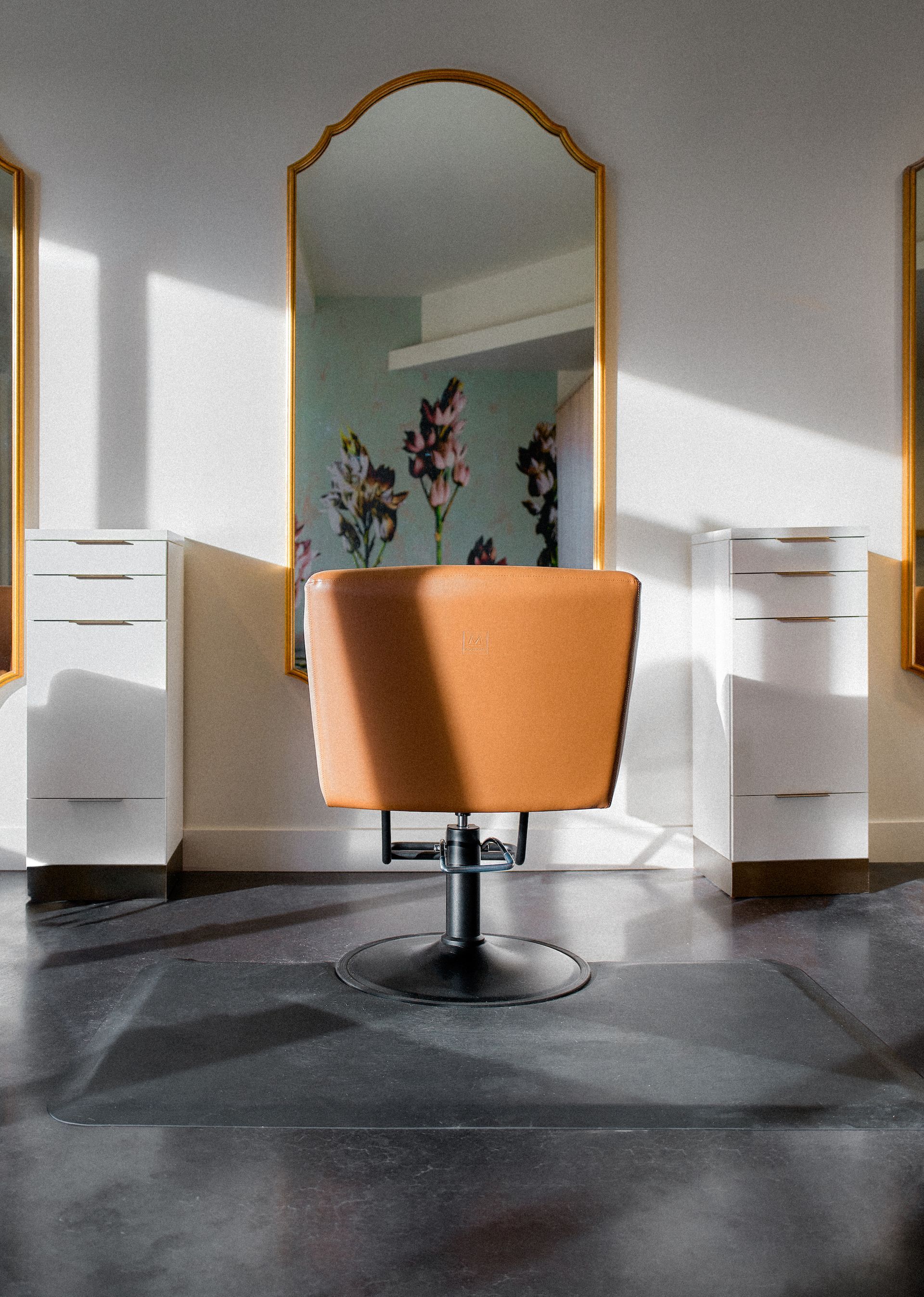 An empty hair salon with a chair and a mirror.