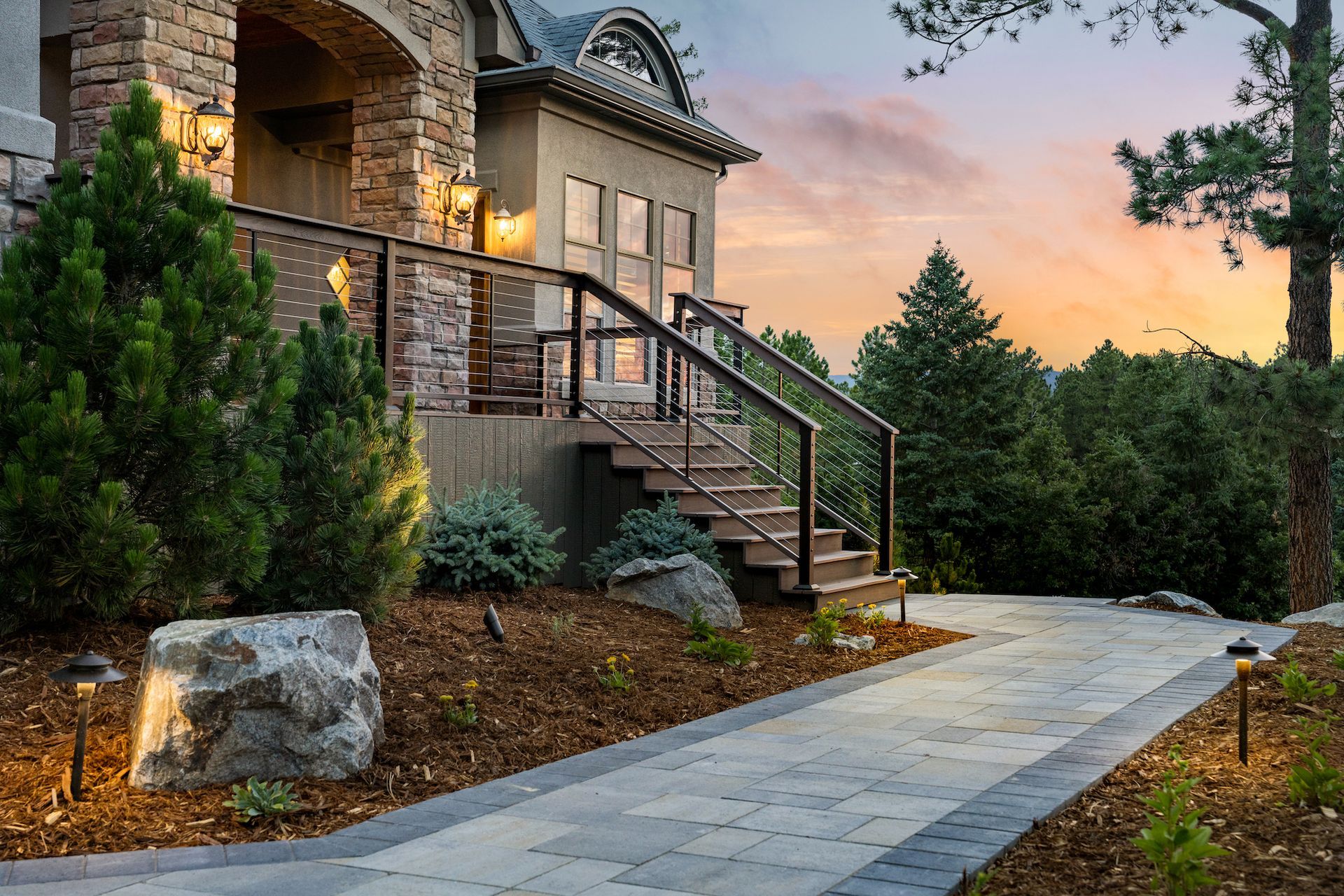 A large house with stairs and a walkway leading to it.