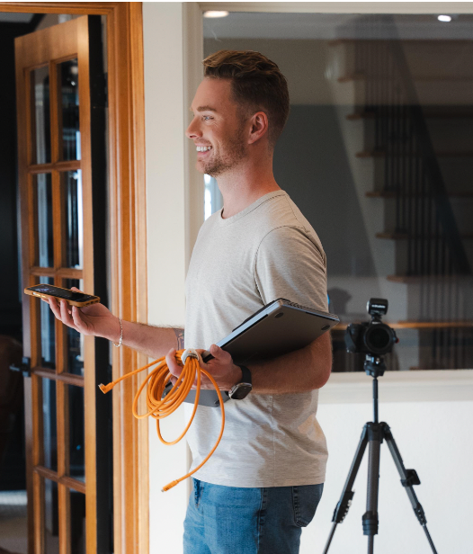A man is holding an orange cord and a clipboard