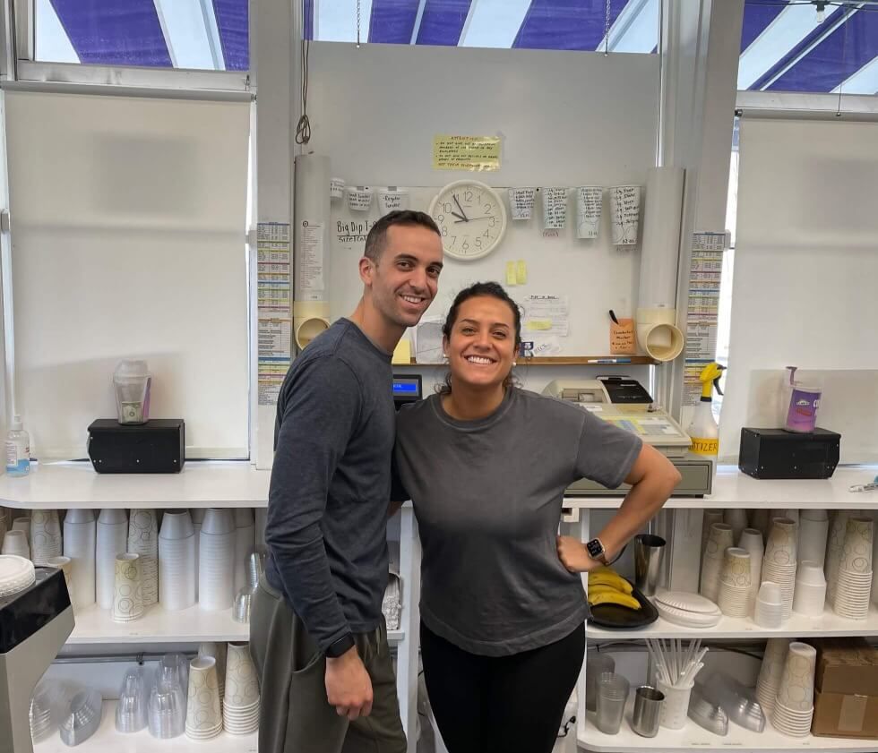 A man and a woman are posing for a picture in the shop