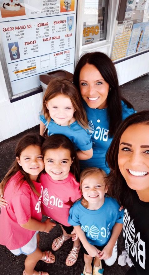 A woman is taking a selfie with a group of young girls.