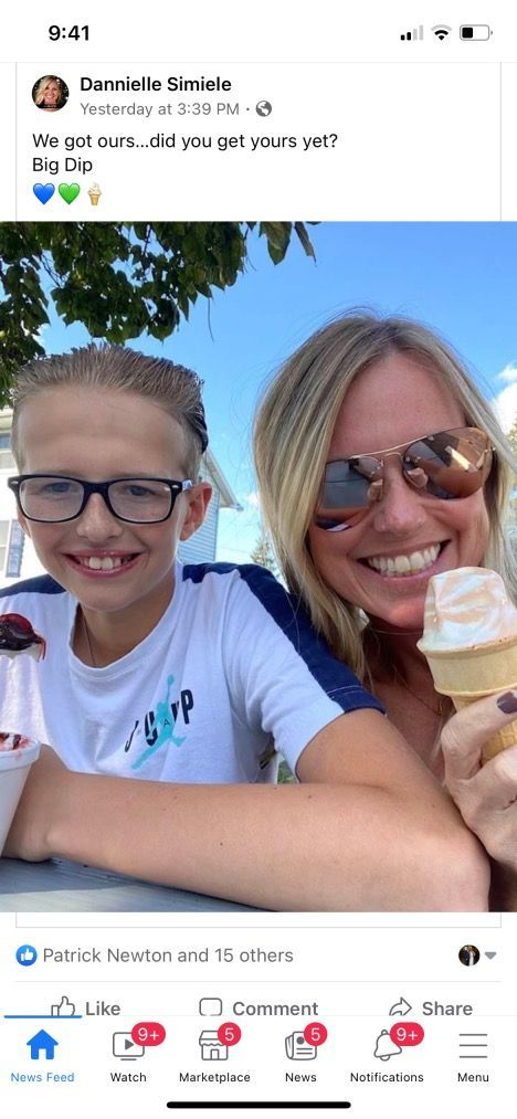 A woman and a boy are sitting next to each other eating ice cream.