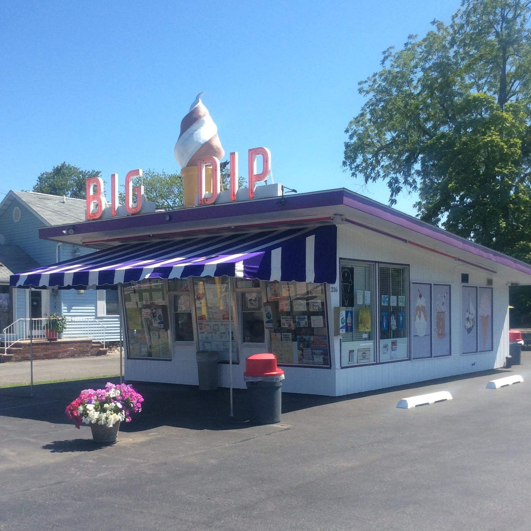 A white building with a purple awning that says big dip