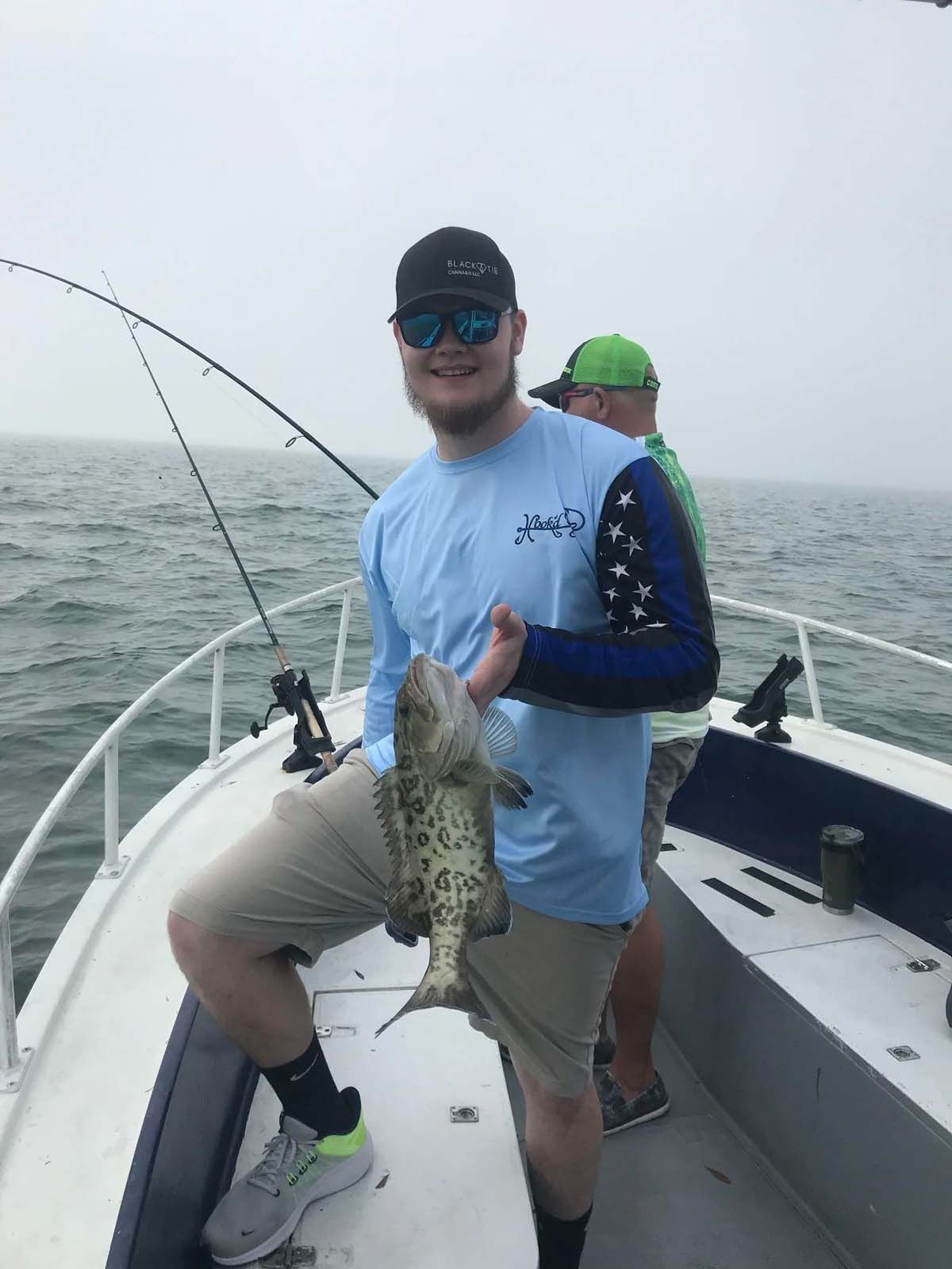 A man is holding a fish on a boat.