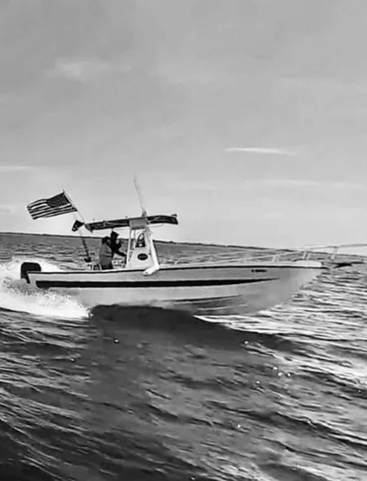 A black and white photo of a boat floating on top of a body of water.