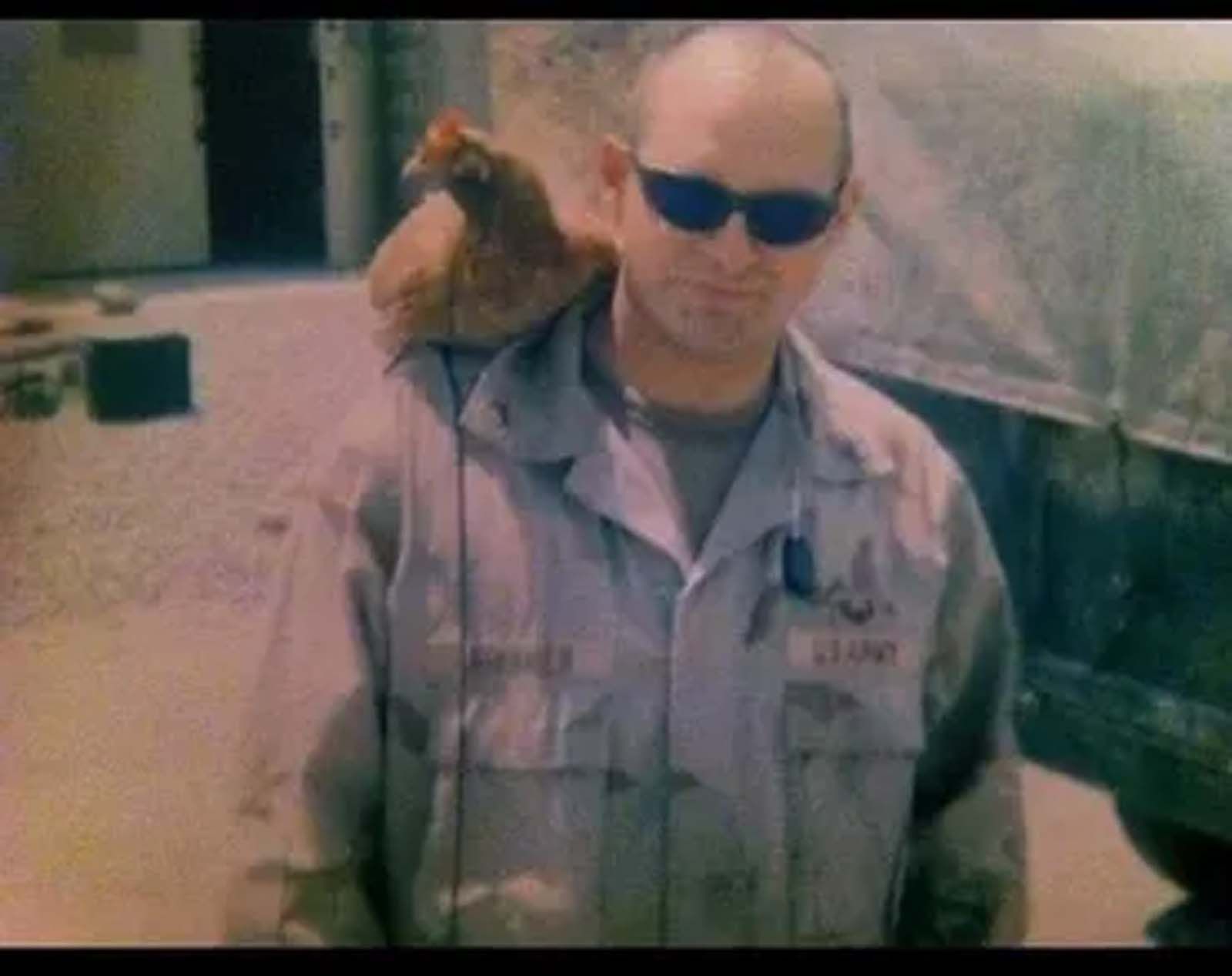 A man in a military uniform is holding a bird on his shoulder