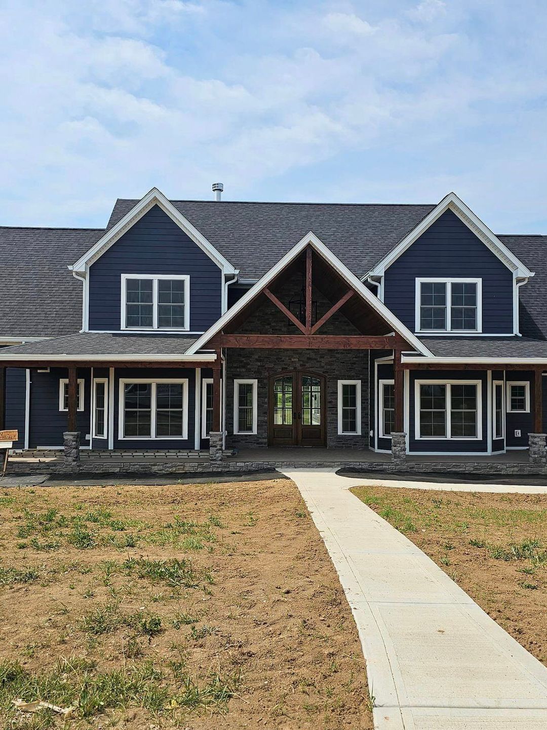 A large house with a lot of windows and a walkway leading to it.