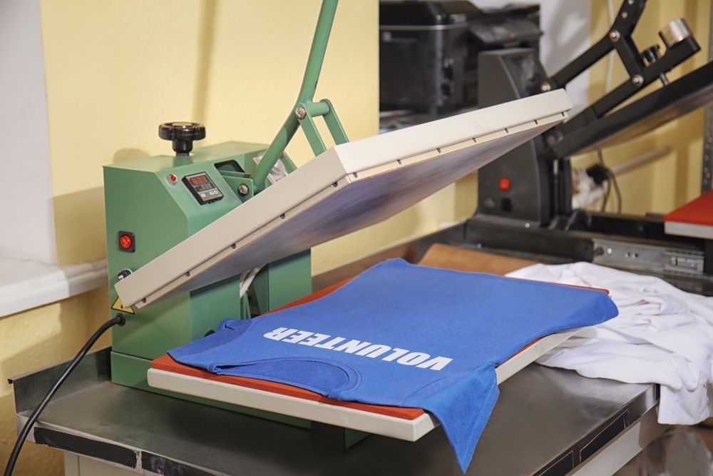 A Blue Shirt with The Word Volunteer on It Is Being Printed on A Machine — Imsprint in Muswellbrook, NSW
